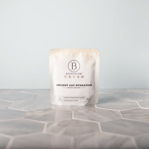 Luxe Bath Ritual Kit | Live Love Spa featuring Bathorium Crush Ancient Oat Hydration bath soak in minimalist packaging on a tiled surface, promoting skincare and wellness.