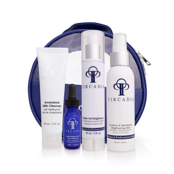 Set of four skincare products including cleanser, serum, brightener, and mist in front of a navy blue cosmetic bag, labeled Pigmentation Regimen Bundle | Circadia.
