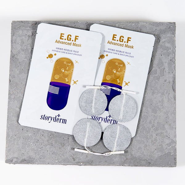 Restorative Facial Sheet Mask Set - 2 Mask Kit | 7e Wellness featuring two E.G.F Advanced Mask packets and four circular skincare patches arranged on a textured stone surface.